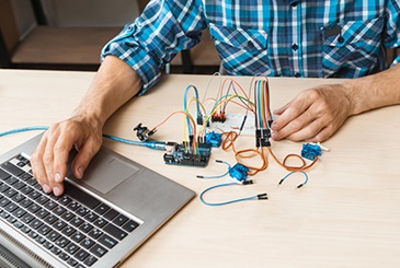 Man testing device with laptop