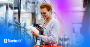 Young woman enjoys smart shopping with a smartphone in a vibrant grocery aisle.